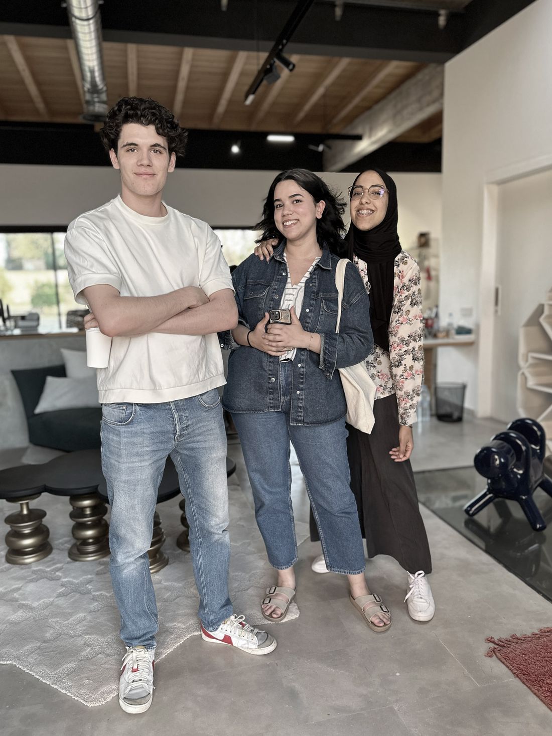 Three young creatives standing together inside the studio